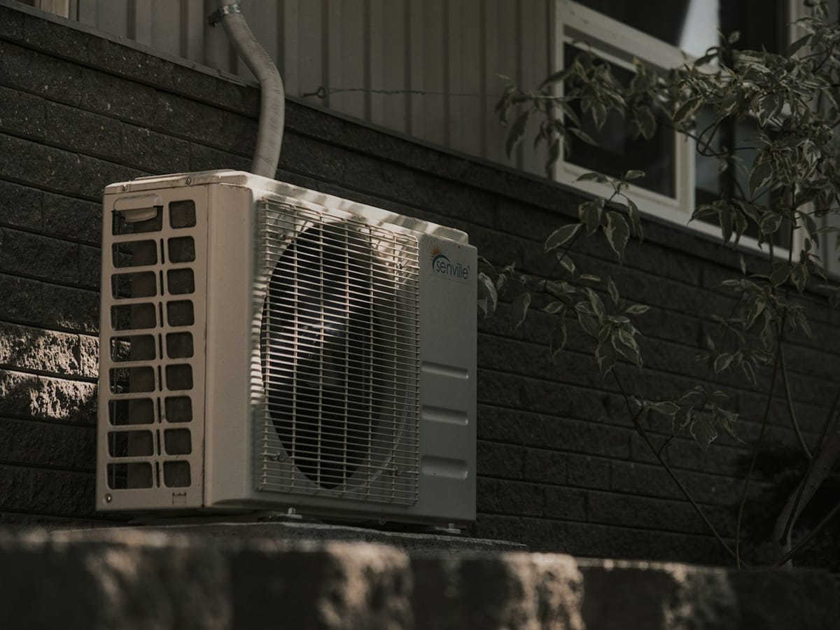 A mini-split outdoor unit beside a house
