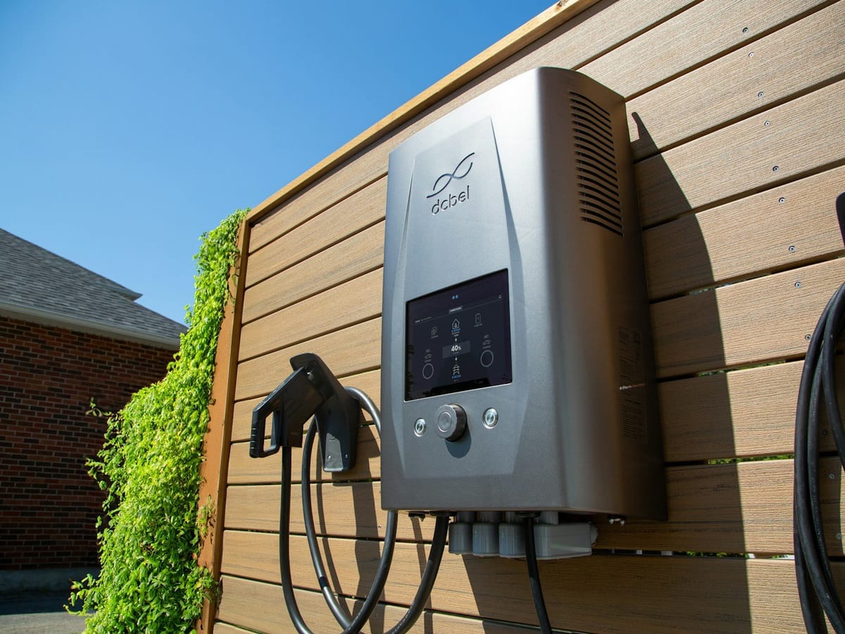 A home EV charger mounted on a fence