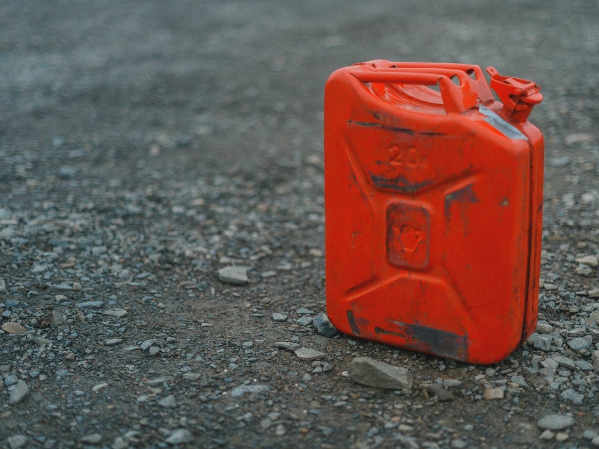 A red metal fuel can on gravel